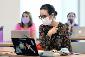 Students refer to their laptop computers during a presentation (July 2021)